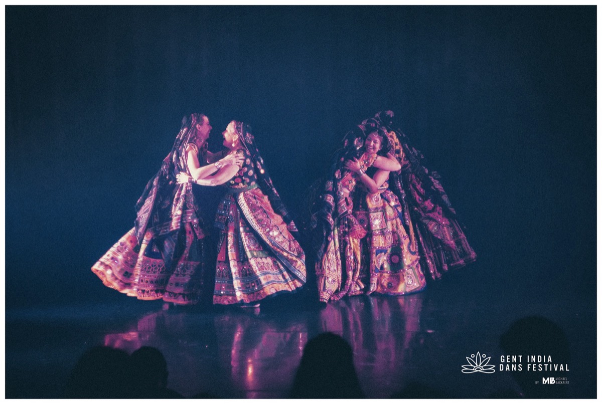 Two ABC dancers mid-spin in the dark — skirts catching the light