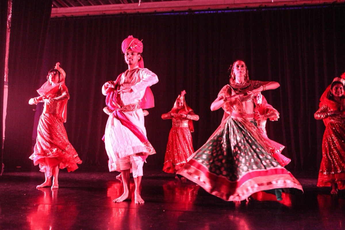 The ABC company in a Rajasthani set under red stage light